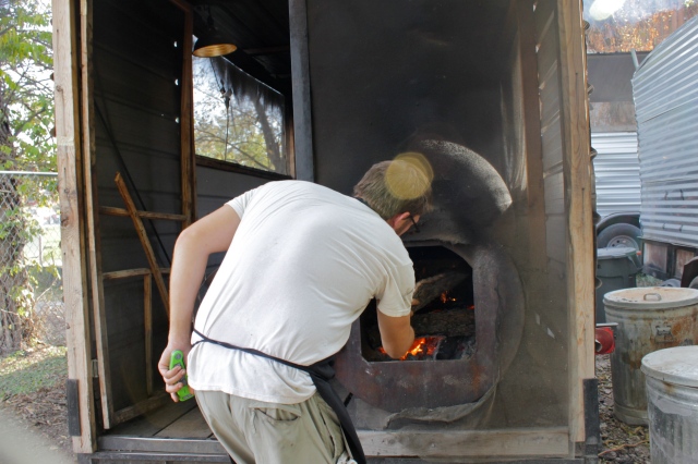 Loading wood into the smoker at Franklin Barbecue, Austin, TX